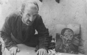 Il pittore accanto a uno dei suoi tanti autoritratti