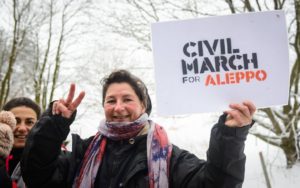 Signora con gesto di vittoria e cartello della marcia 12 -1-17