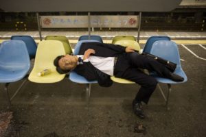 Giapponese che dorme su panchine- Overwork